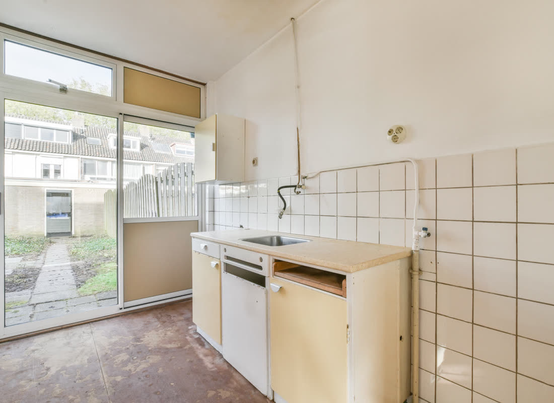 A dated kitchen with original cabinetry and worn finishes