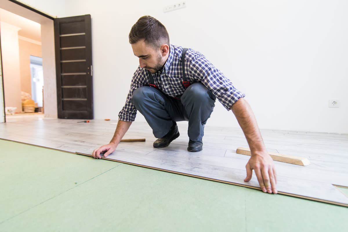 A fitter laying finished floor boards onto a prepared base