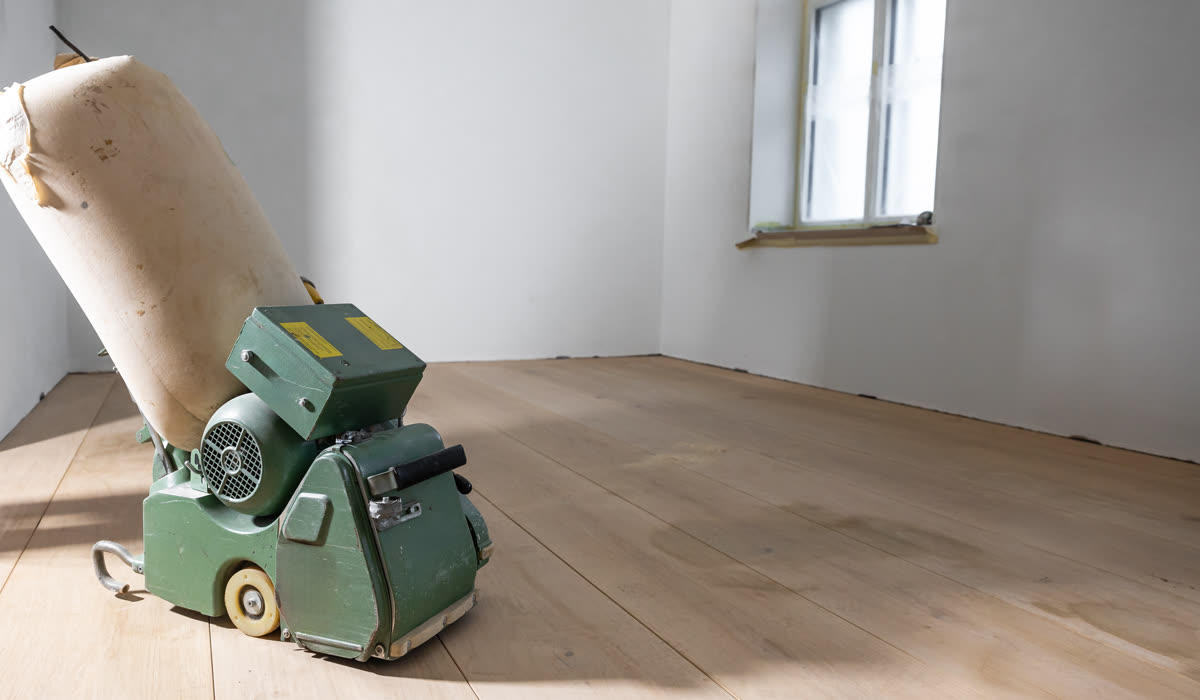 A floor sanding machine part-way across a wooden floor
