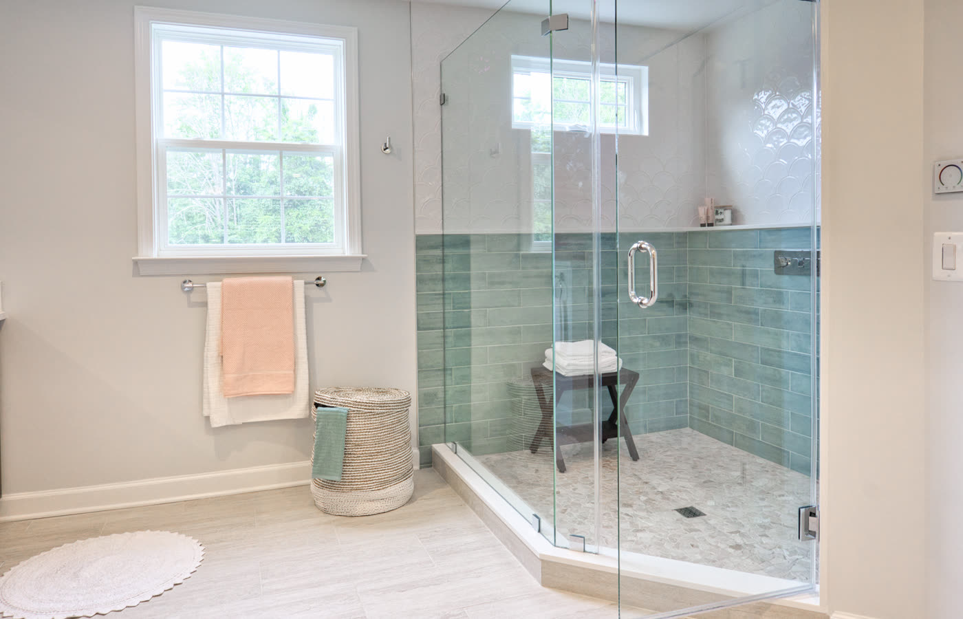 A renovated bathroom with a glass shower enclosure